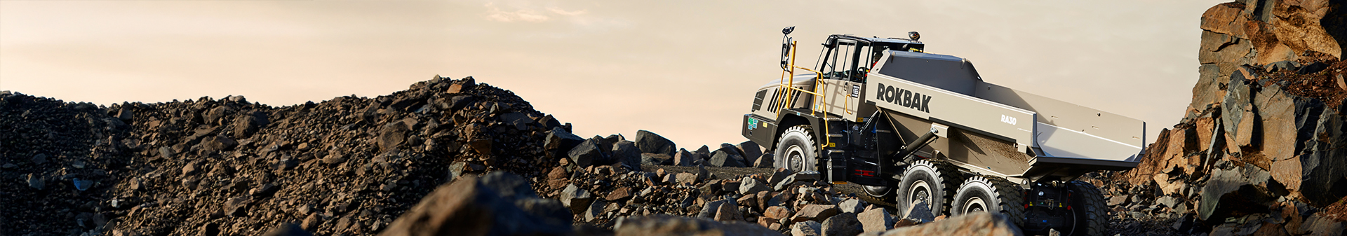 Rokbak RA30 adt fitted with rugged mining tyres driving through a dusty mining site.