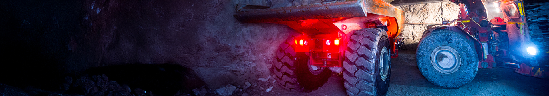 Underground specialty machinery fitted with durable underground specialty machinery tires operating in a dimly lit mining tunnel.