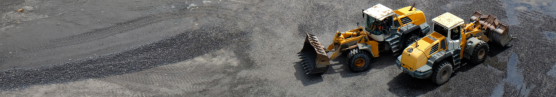 Wheel loaders equipped with durable wheel loader tires working on a gravel surface at a construction site.